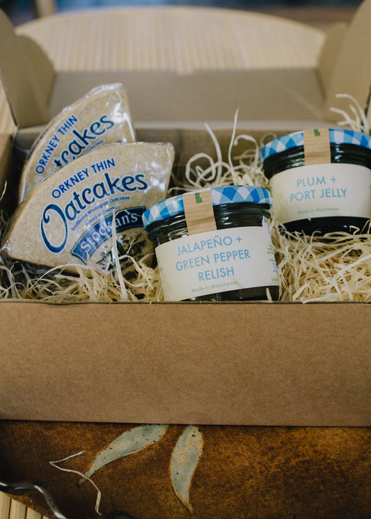 Festive cheeseboard Box containing Oatcakes, jelly, and jalapeño green pepper relish. Perfect gift for cheese lovers. 